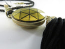 Close view of gold-tone geometric oval pendant