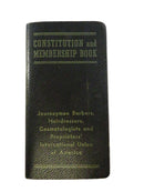Black leather book titled 'Constitution and Membership Book' on a white background
