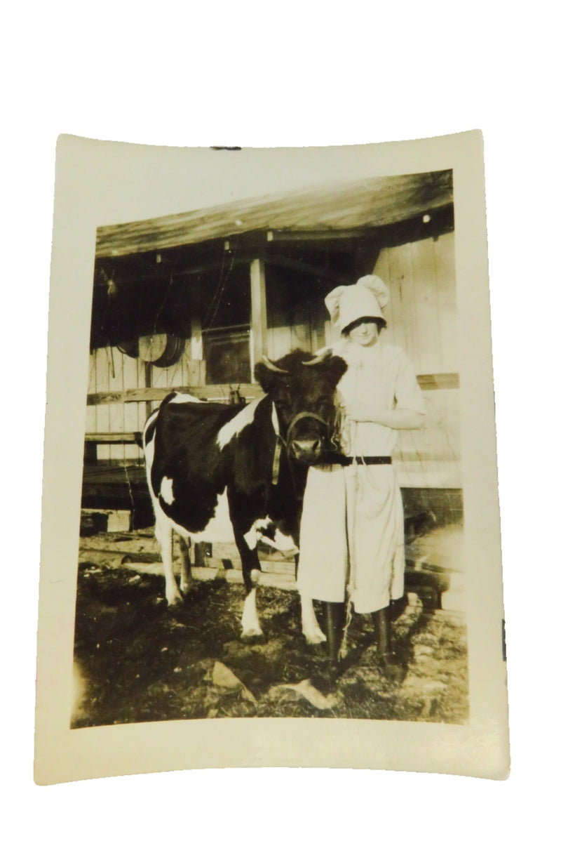 Woman posing With Her Cow Wearing Funny Hat