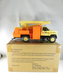 Toy construction vehicle next to its packaging box on a white background