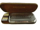 Open Rolls Razor travel pouch showing chrome-plated razor storage chassis, blade-bank case, and Rolls Razor strop lid insert.