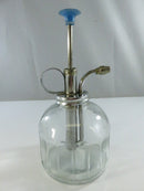 Angled close view of the metal pump assembly and finger ring handle on the clear glass plant mister