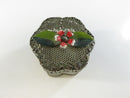 Side view of the vintage mesh metal trinket box showing scrollwork filigree border and scalloped base