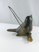 Underside view of the bird figurine showing the battery compartment and on/off switch