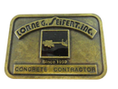 Front of brass-tone Lorne G. Seifert, Inc. Concrete Contractor belt buckle with black enamel lettering and construction equipment graphic