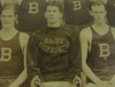 Close-up of the center athlete's Saint Benedict's sweatshirt and adjacent block B uniforms.