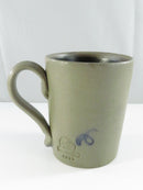 Underside view of the mug showing its unglazed circular stoneware base and handle.