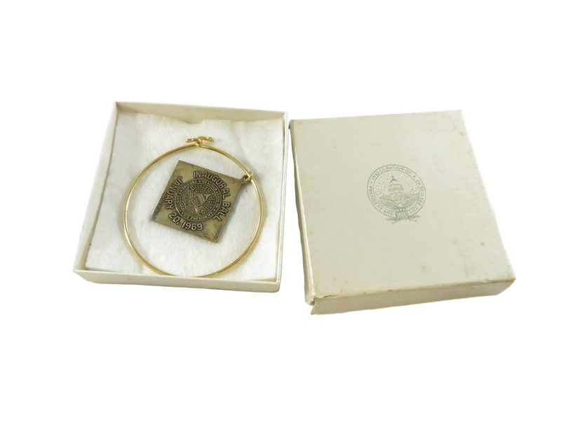 Gold pendant in a box with a white background