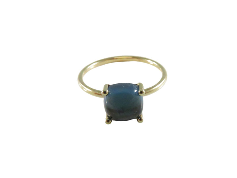 Gold ring with a blue gemstone on a white background