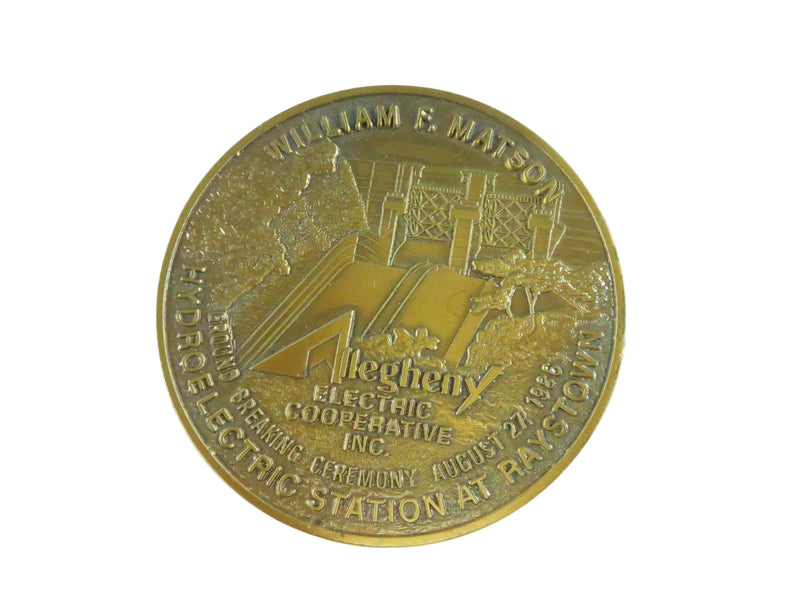 Bronze medal with engraved text and design on a white background