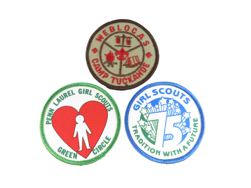 Three Girl Scout patches on a white background