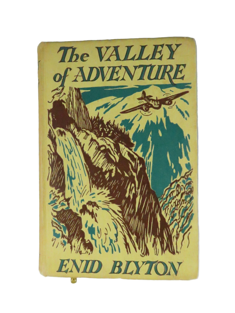 Book cover of 'The Valley of Adventure' by Enid Blyton with mountain and airplane illustration.