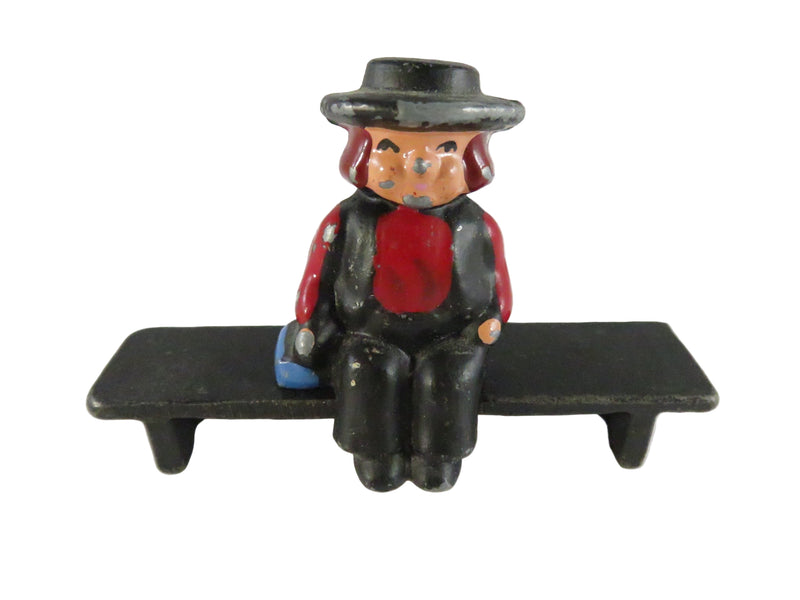 Figurine of a person sitting on a bench with a white background