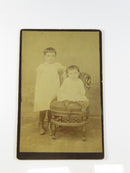 Vintage sepia-toned photograph of two people sitting together on a white background