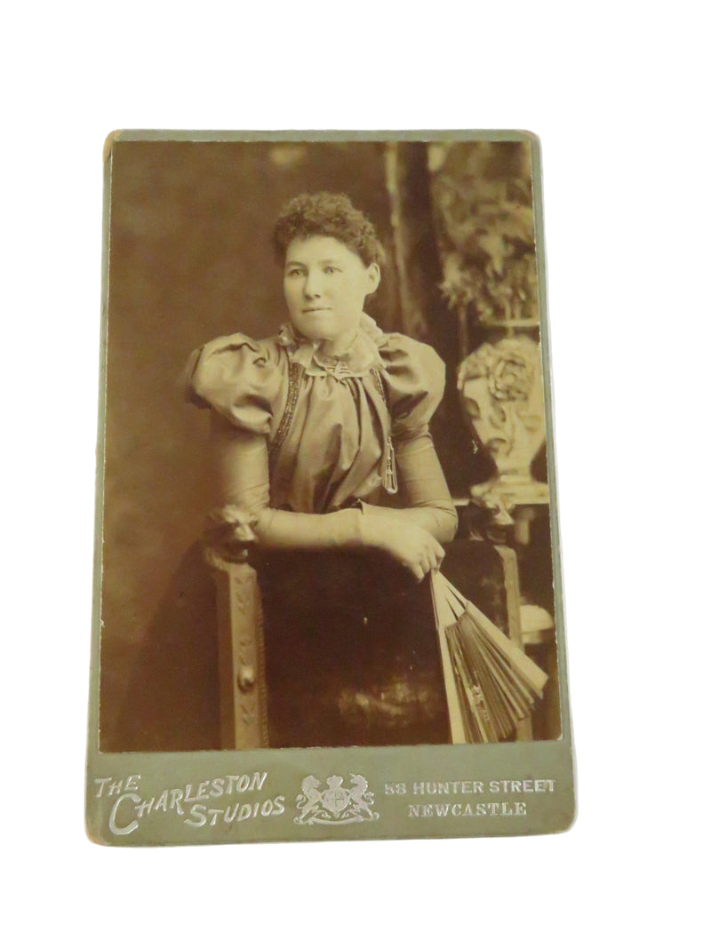 Vintage sepia-toned photograph of a woman, likely from the late 19th or early 20th century, with 'Carleston Studios' branding.