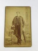 Vintage sepia-toned photograph of a man holding a sword on a decorative background