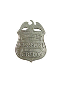 Metallic badge with 'CENSUS 1910' text on a white background