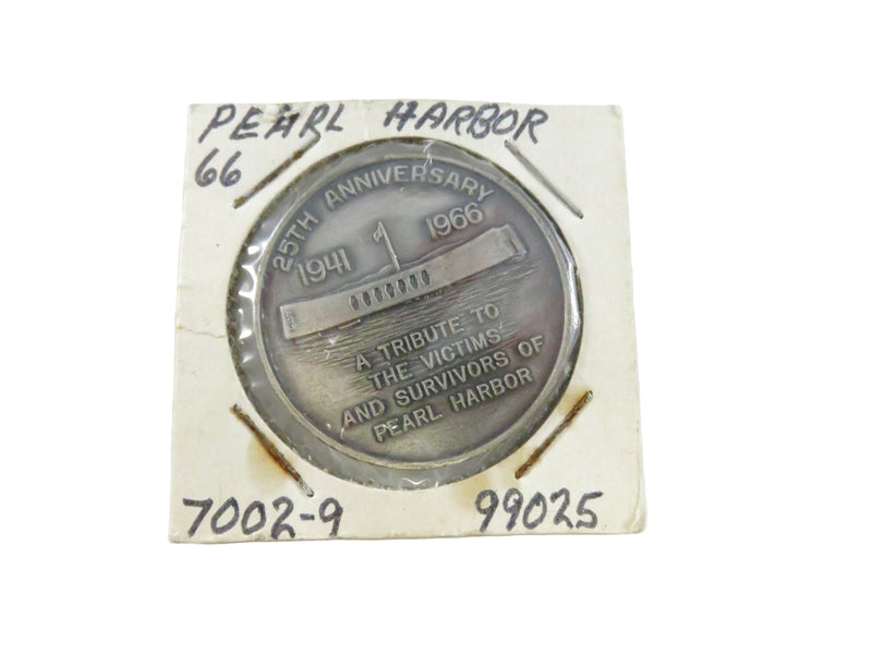 Silver coin commemorating the 25th anniversary of Pearl Harbor on a white card with text.