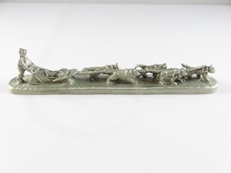 Decorative sculpture of a sled with dogs on a white background