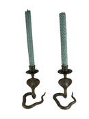 Pair of vintage candle holders with green candles on a white background