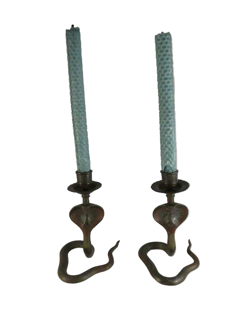 Pair of vintage candle holders with green candles on a white background
