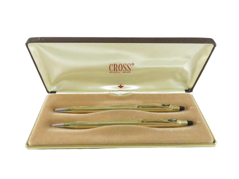 Two gold pens in a Cross branded case on a white background