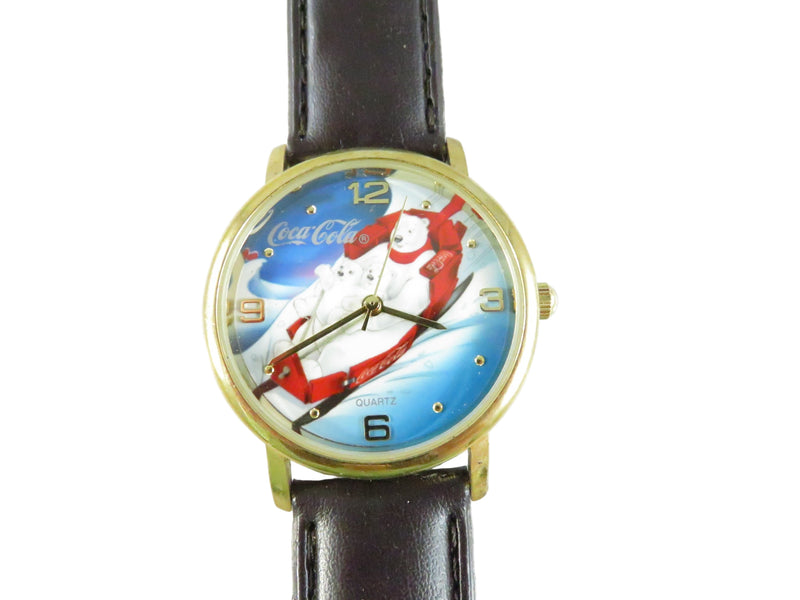 Wristwatch with Coca-Cola-themed face featuring a polar bear and Santa Claus on a white background