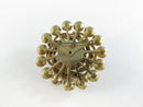 Reverse of gold-tone rhinestone brooch showing safety catch pin back