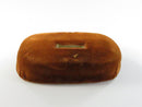 Underside of rust orange velvet display riser with dark base
