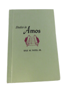 Green hardcover front cover of Studies in Amos by Kyle M. Yates, Jr., with a maroon scroll illustration.