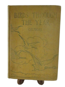 Front cover of Birds Through the Year by Gilmore, a worn tan hardcover with bird illustrations.