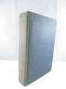 Angled view of blue cloth hardcover showing the gilt-lettered spine and blind-stamped front cover title