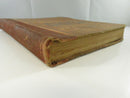 Angled view of the lower spine, fore edge, and worn cloth boards of the hardcover.