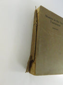 Close side view showing the detached spine and exposed page block of the softcover book.