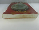 Low front-edge view of the red paperback, showing warped and water-stained page edges.