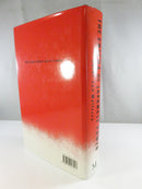 Angled rear view of the red and cream dust jacket and spine, showing the title, author name, barcode, and Macmillan mark.