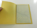 Opened yellow cardstock sleeve holding the folded multi-panel New England road map.