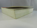 Bottom edge view of the paperback text block, showing waviness and age-toned page edges.