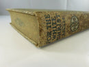 Low-angle view of the worn spine, frayed cloth, and heavily worn page edges.