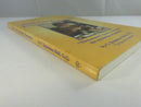 Angled view of the yellow paperback's front cover and spine, showing cover wear and the title on the spine.