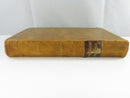 Fore-edge view of the book showing a wavy, toned text block and worn leather board edges.