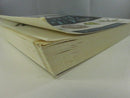 Low angled view of the paperback showing curled cover edges and the thick, worn page block.
