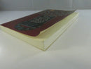 Angled view of the paperback showing curled cover edges, toned page block, and wear to the binding.