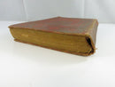 Side view showing the aged, soiled page edges and worn red cloth boards.