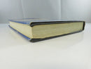 Lower edge and fore-edge view of the hardcover text block and worn dust jacket.