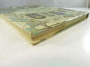 Angled view of the book from the fore-edge, showing the dust jacket, page block, and worn jacket corners.