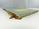 Opened front endpapers showing extensive dark offset staining from the degraded wrap and the handwritten inscription, “To Nora From Helen.”
