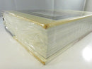 Close view of the top page edge and upper cover corner beneath the original shrinkwrap.
