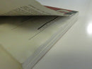 Open paperback showing a severely warped page and separating binding near the text block.