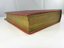 Top edge of the hardcover showing gilt page edges, toning, and chipped cloth at the corners.